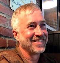 A person smiling at the camera

Description automatically generated